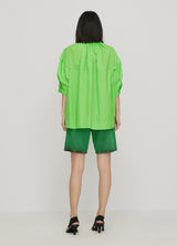 junge Frau in grüner Ballon-Bluse von JNBY; Hinteransicht