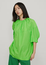 junge Frau in grüner Ballon-Bluse von JNBY; Frontansicht