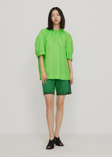 junge Frau in grüner Ballon-Bluse von JNBY; Ganzkörper Frontansicht